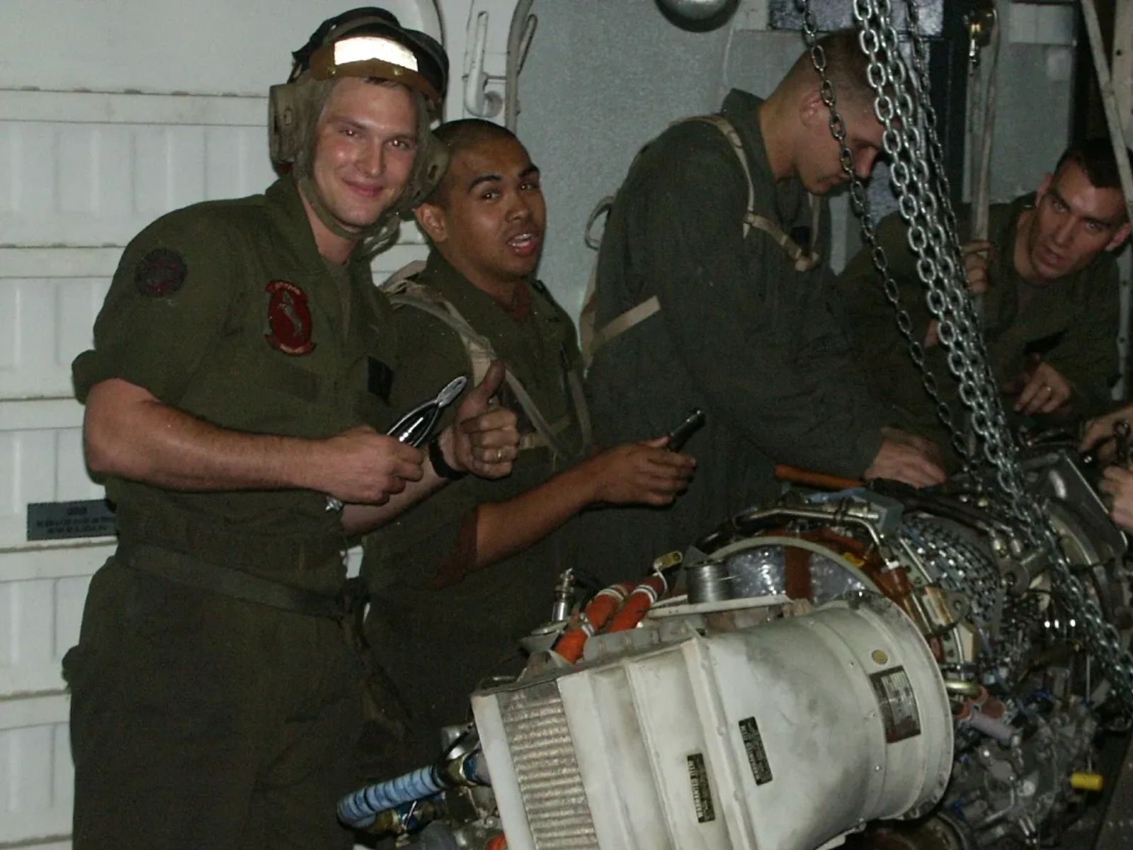 Rob McCaleb working on helicopter engine with Marine Corps squad